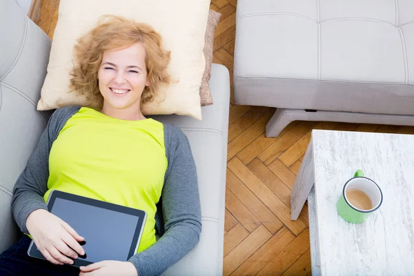 Woman relaxing with a Tablet PC on the sofa — Stock Photo, Image