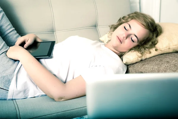 Kvinna som sover på natten med en Tablet Pc i soffan — Stockfoto