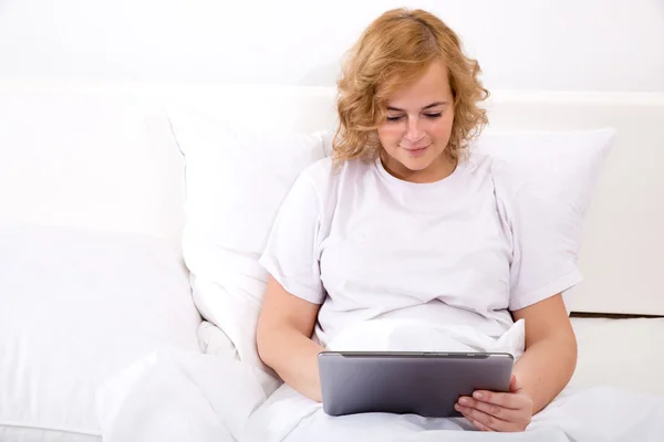 Young woman using a Tablet PC in bed — Stock Photo, Image