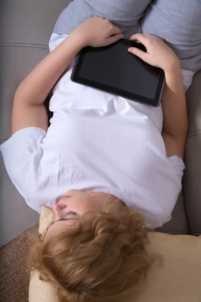 Donna che dorme di notte con un Tablet PC sul divano — Foto Stock