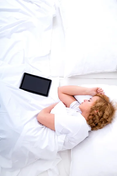 Junge Frau schläft mit Tablet-PC im Bett — Stockfoto