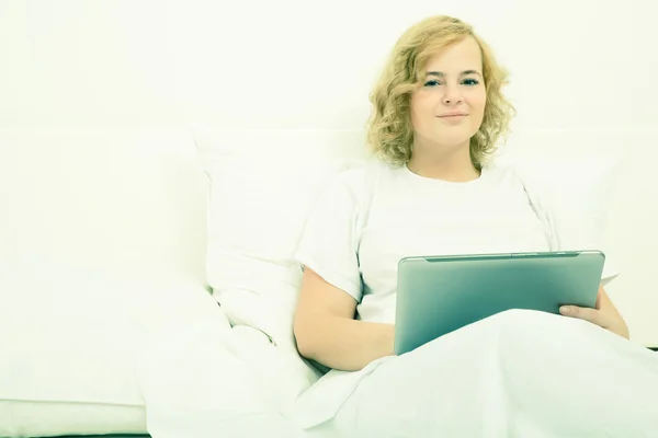 Genç kadın yatakta bir Tablet PC'yi kullanma — Stok fotoğraf