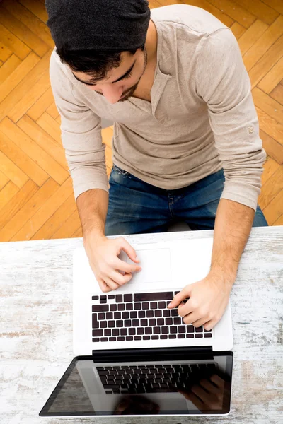 Ung man att skriva på sin laptop — Stockfoto