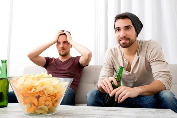 Twee vrienden thuis televisie kijken — Stockfoto