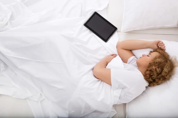 Mladá žena spí v posteli s počítači Tablet Pc — Stock fotografie