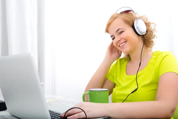 Young plus size woman listening to Audio while working on a lapt — Stock Photo, Image