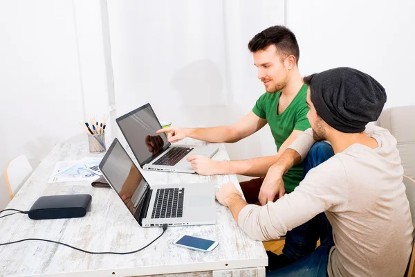 Zwei junge Männer, die im Büro arbeiten — Stockfoto