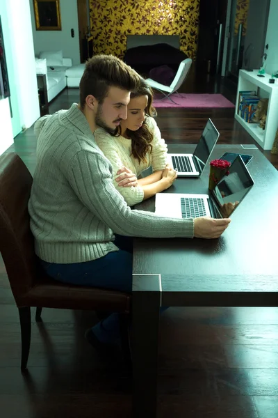 Casal jovem discutindo na frente de um PC Laptop em casa — Fotografia de Stock