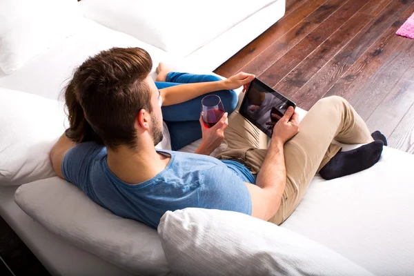 Jong stel met behulp van een tablet PC samen op de Sofa thuis — Stockfoto
