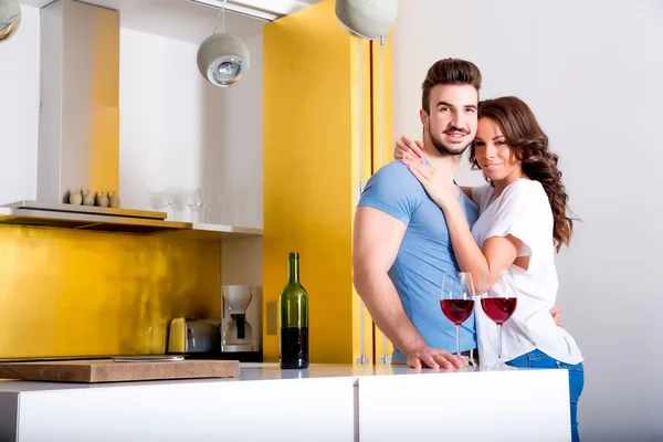 Pareja joven bebiendo vino en la cocina —  Fotos de Stock