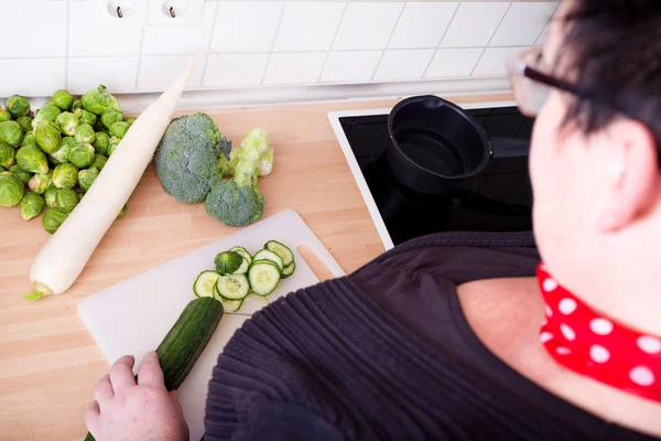 Femme coupant des légumes — Photo