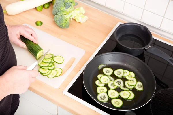 Woman cutting cucumber — Stock Photo, Image