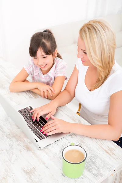 Madre e figlia con un computer portatile a casa — Foto Stock