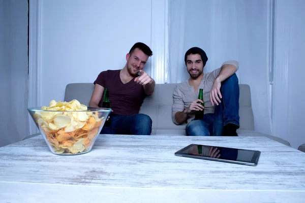 Dos amigos viendo televisión en casa — Foto de Stock