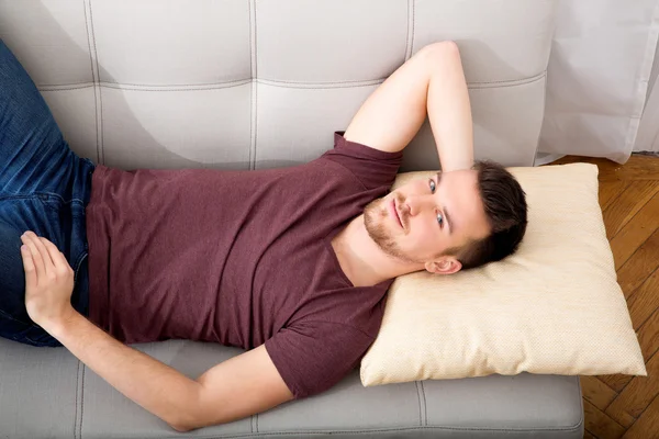 Young man lying on the sofa — Stock Photo, Image