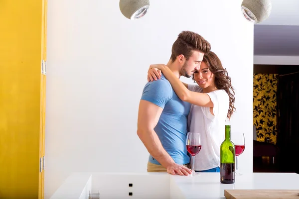 Молодая пара пьет вино на кухне — стоковое фото
