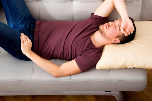 Mooie jonge vrouw liggend op de bank — Stockfoto