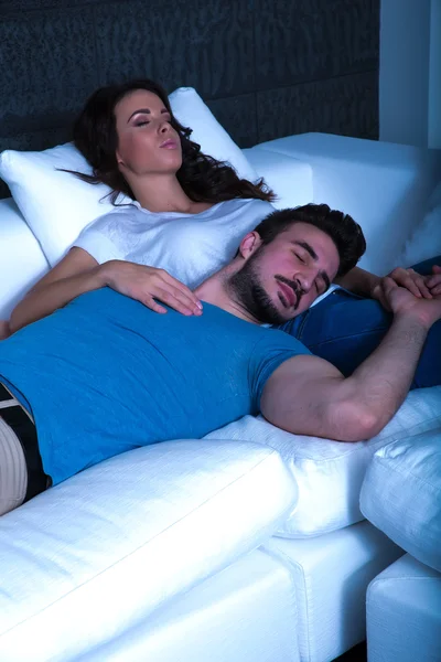 Young couple sleeping on the sofa at night