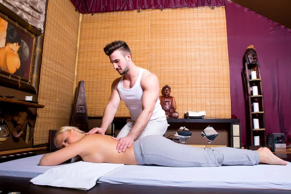 Jovem mulher adulta recebendo uma massagem — Fotografia de Stock