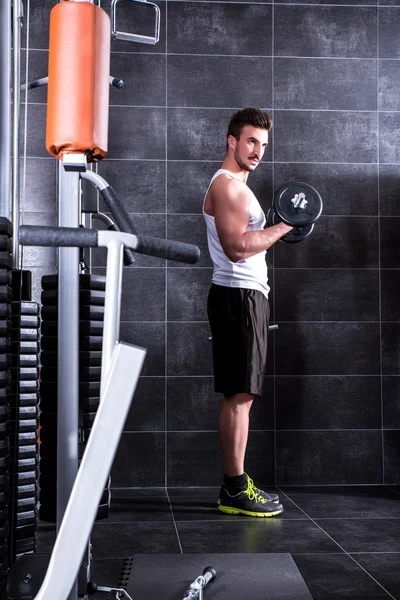 Jeune homme travaillant dans la salle de gym — Photo