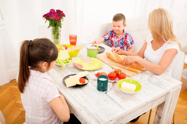 Gelukkig gezin ontbijten thuis — Stockfoto