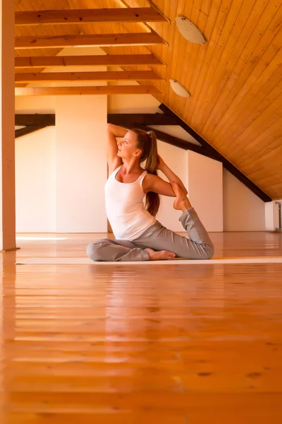 Vrouw die yoga beoefent in een studio — Stockfoto