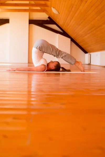 Vrouw die yoga beoefent in een studio — Stockfoto