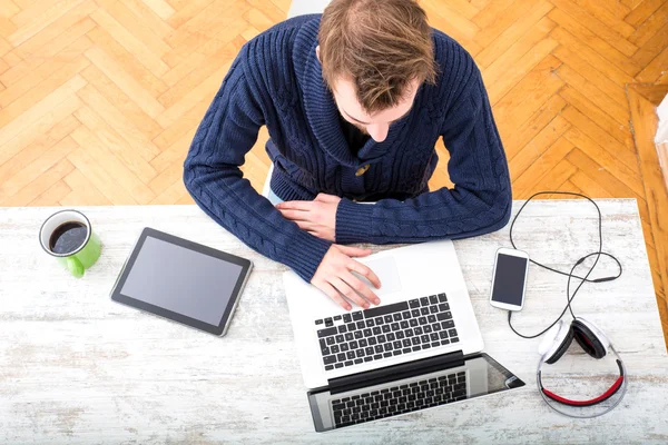 Mladý muž online pracující v domácí kanceláři — Stock fotografie