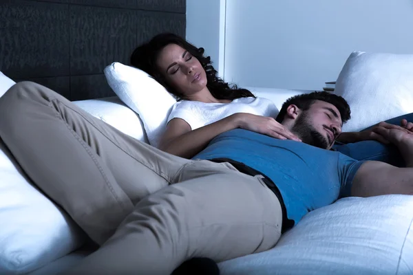 Young couple sleeping on the sofa at night