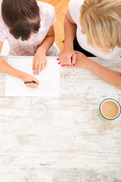 Mother helping her daughter with the homework — Stock Photo, Image