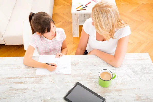 Mamma att hjälpa dottern med läxor — Stockfoto