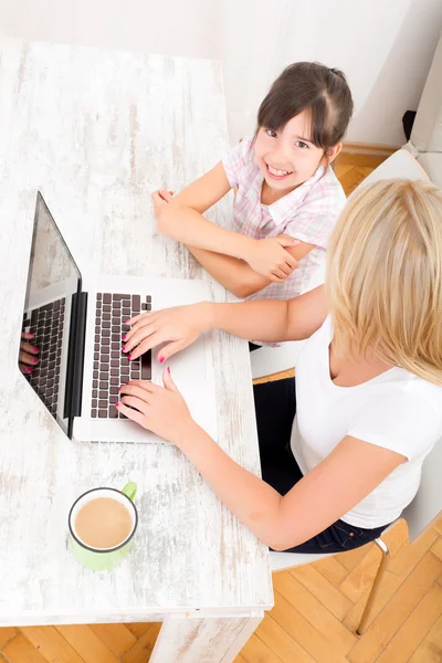 Anne ve kızı evde bir dizüstü bilgisayar ile — Stok fotoğraf