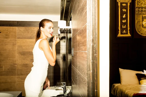 Mulher bonita colocando maquiagem no banheiro — Fotografia de Stock
