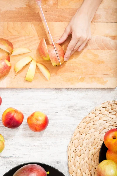 Cutting apple while getting online information about nutrition — Stock Photo, Image