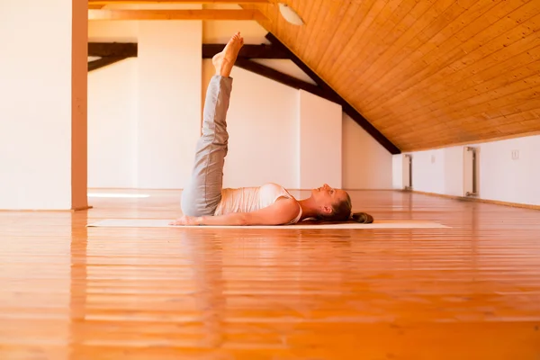 Kvinna som utövar yoga i en studio — Stockfoto