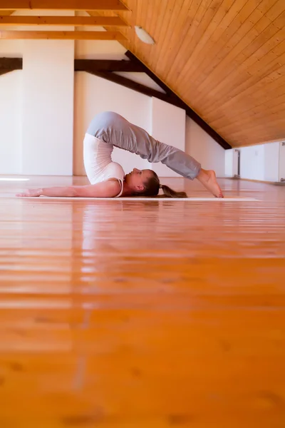 Kvinna som utövar yoga i en studio — Stockfoto