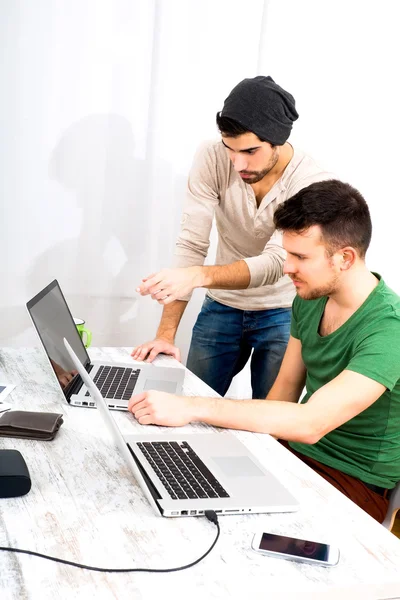 To medarbeidere diskuterer noe på kontoret. – stockfoto