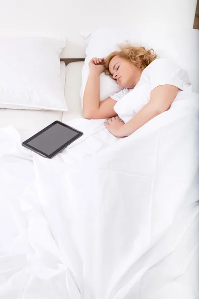 Jonge vrouw slapen in Bed met een Tablet Pc — Stockfoto