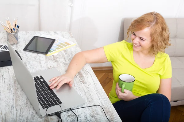 Unga plus size kvinna som arbetar på en bärbar dator — Stockfoto