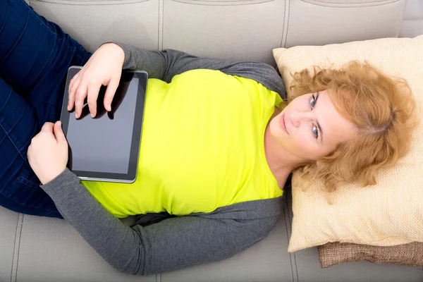 Young adult woman with a Tablet PC on the Sofa — Stock Photo, Image