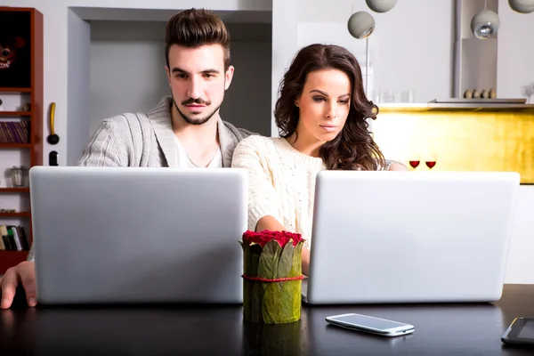 Young couple in front of their Laptop Computers at home — Stock Photo, Image