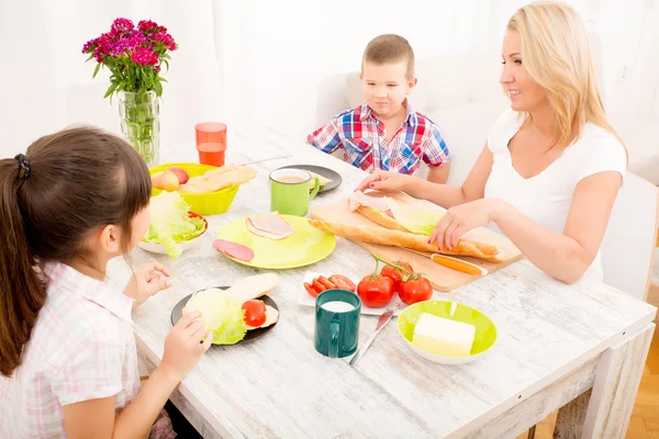 Gelukkig gezin ontbijten thuis — Stockfoto