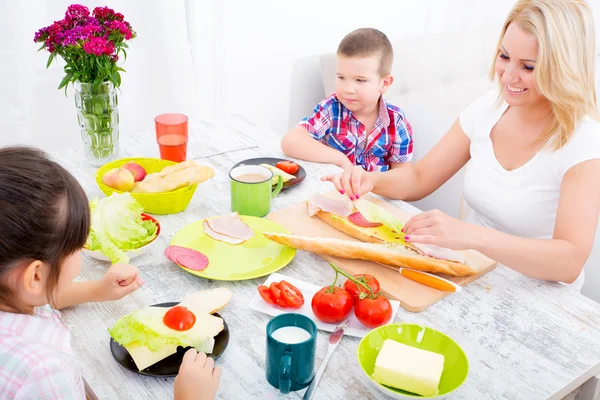 Happy family having breakfast at home — Stock Photo, Image