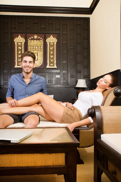 Una joven pareja de vacaciones disfrutando de su habitación de hotel — Foto de Stock