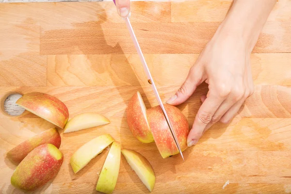 Cutting apple while getting online information about nutrition — Stock Photo, Image