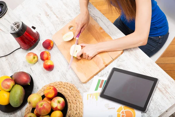 Smoothie zubereiten und sich gleichzeitig online über Nutrit informieren — Stockfoto