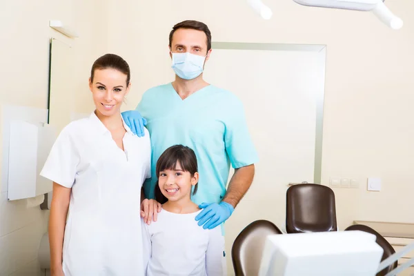 Equipe de dentista com uma garotinha — Fotografia de Stock