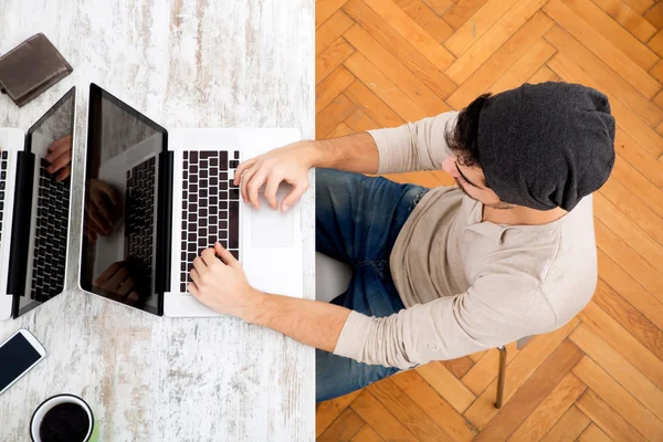 Mladý muž, psaní na jeho laptopu — Stock fotografie