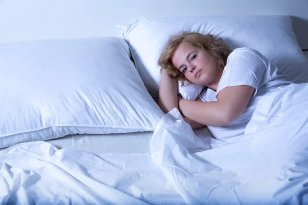 Mujer joven durmiendo en la cama por la noche — Foto de Stock