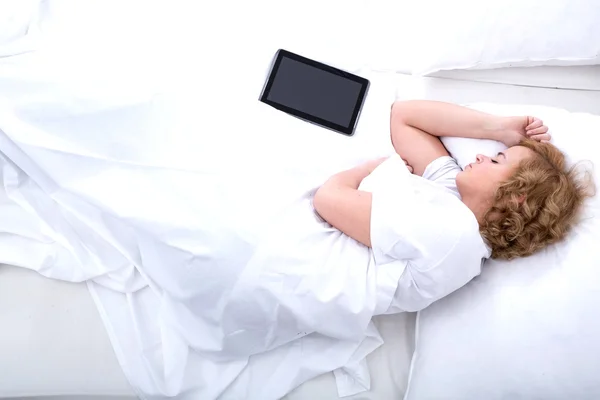 Mujer joven durmiendo en la cama con una tableta PC — Foto de Stock
